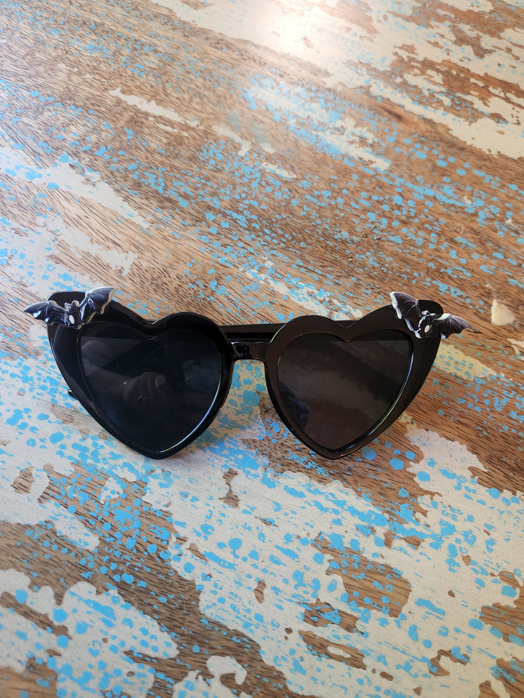 Black Nocturne Bats sunglasses by TORTURE COUTURE featuring bat-shaped frames and dark tinted lenses.