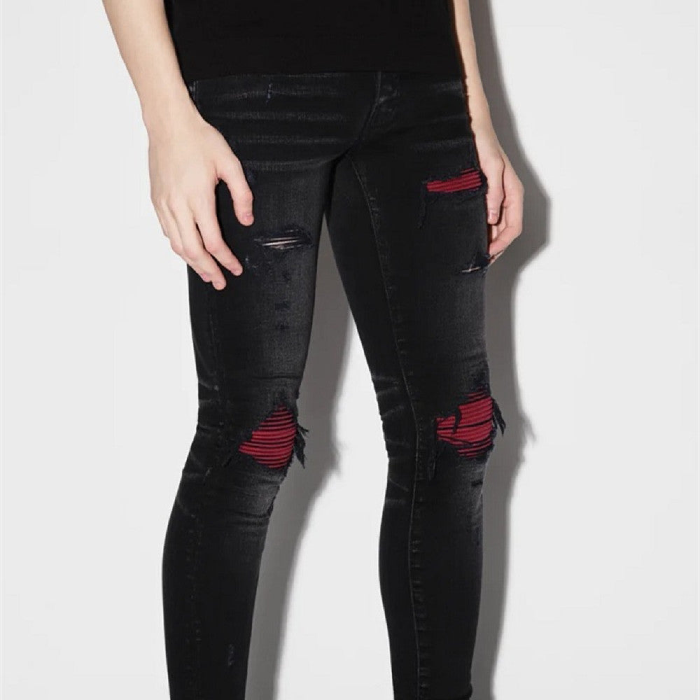 Slim black stretch jeans for men by Blackthorn 31, showing a close-up of the fitted denim fabric and waistband.