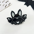Black bat-shaped Halloween hair claw accessory by Green Witch Creations, featuring detailed bat wing design for spooky style.