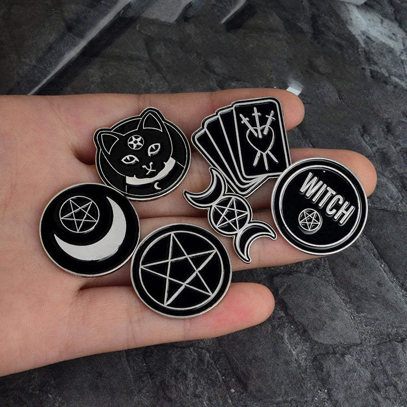 Black and white witchy pins by Green Witch Creations featuring mystical design and witch-themed symbols on metal pins.