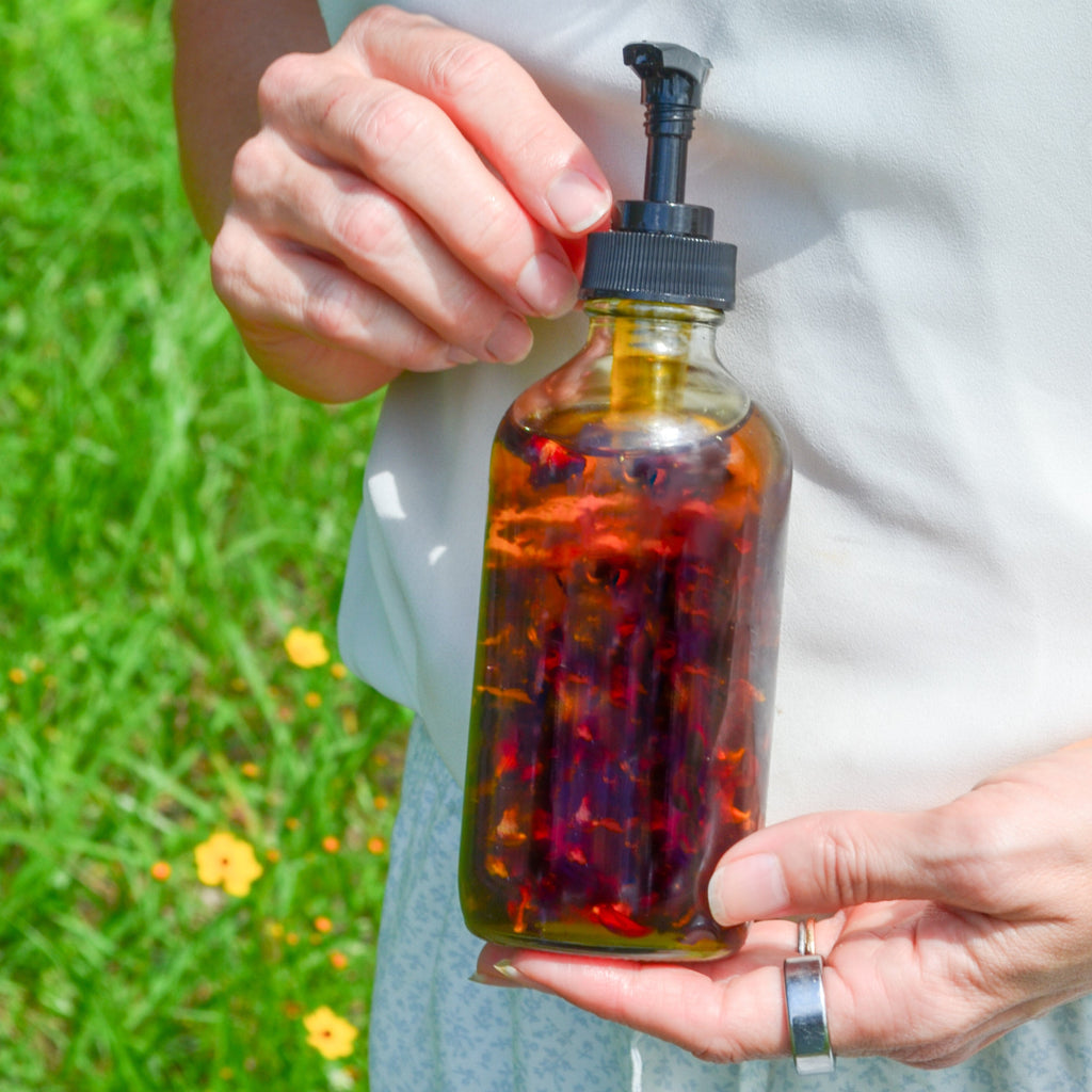 Pretty farm girl Lymph Love natural body oil for lymphatic massages, featuring a clear glass bottle with a dropper and herbal ingredients.